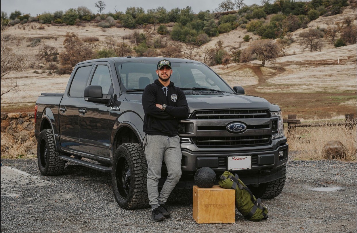 James Biccum, owner of Gym Truck Chico, stands beside the mobile personal training truck in a scenic Chico, CA area, ready to deliver customized one-on-one fitness coaching to your home, office, or local park.
