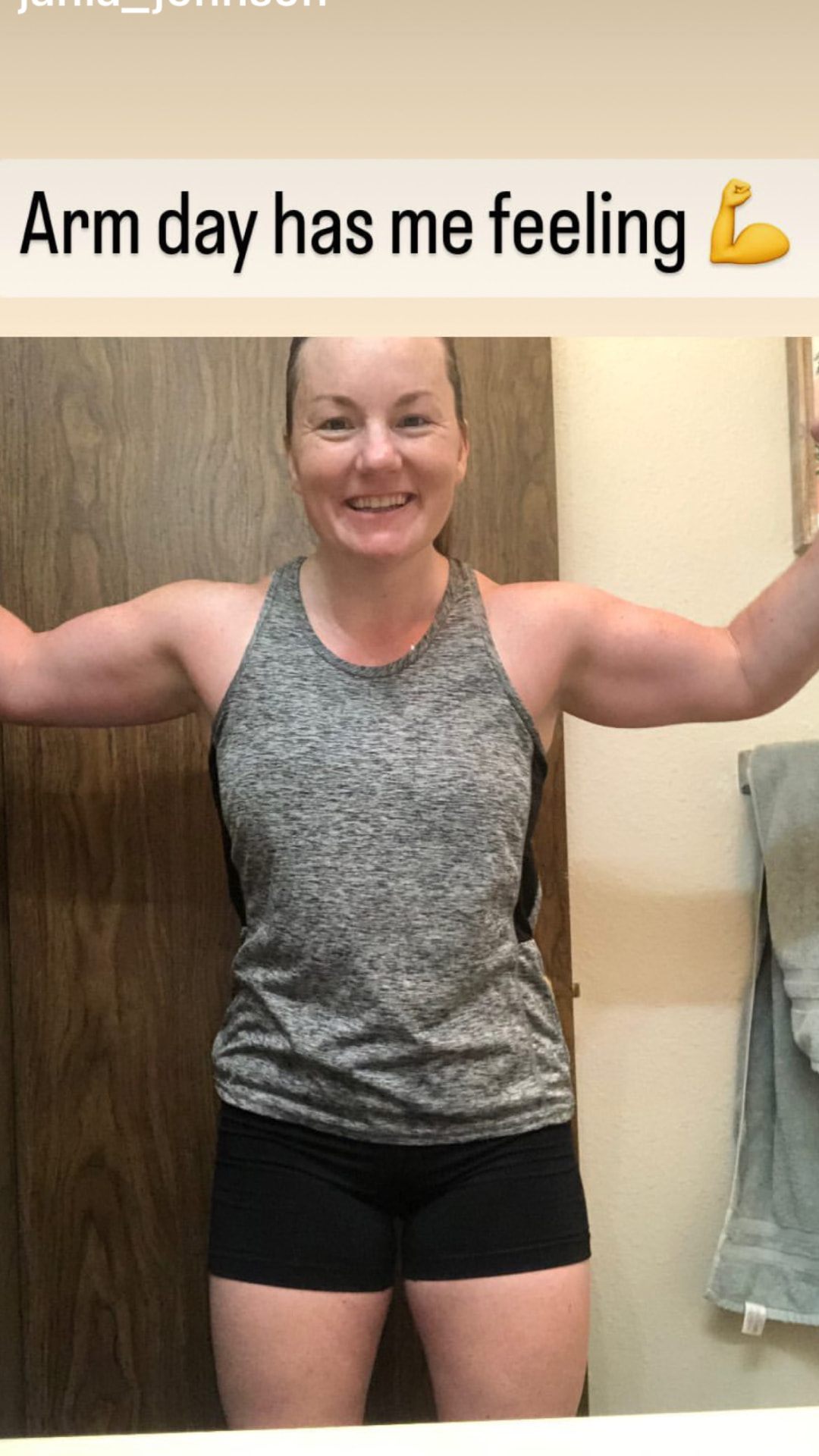 A smiling woman flexes both arms in a mirror with a confident grin, showing the renewed strength and energy clients feel when they get fit again with fully customized personal training from Gym Truck Chico in Chico, CA.